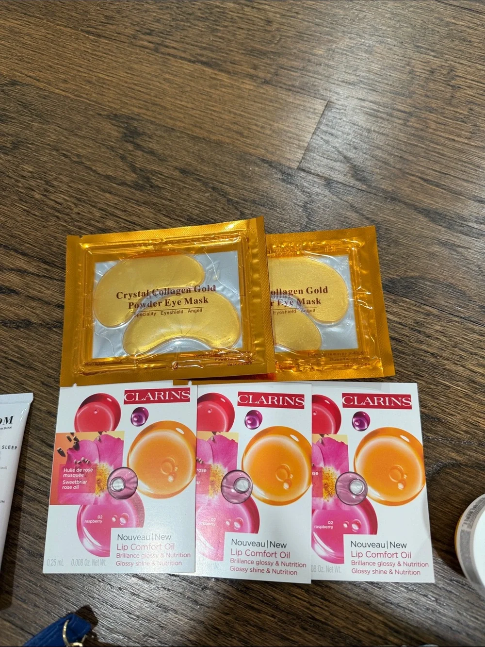 Gingham Wristlet with 2 body creams, 2 eye masks, 3 clarins lip oil samples